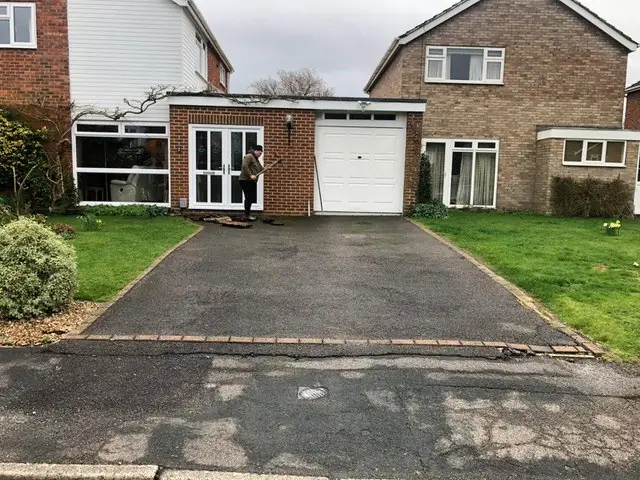 Worn tarmac driveway with a crumbling front edge before replacement