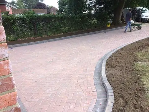 Curved block paved driveway sweeping past a lawn in Godalming