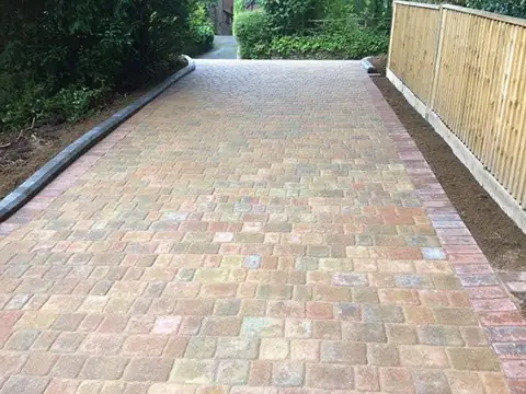 Finished tumbled block driveway running alongside a new closeboard fence