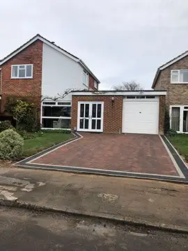 The same driveway after replacement with red herringbone block paving and a charcoal border