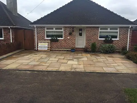 Sandstone slab patio across the front of a bungalow