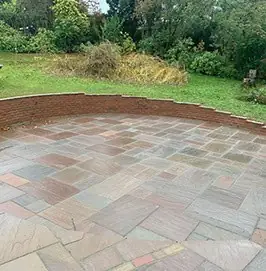 Sandstone patio with a lawn edge in a garden on Great George Street, Godalming