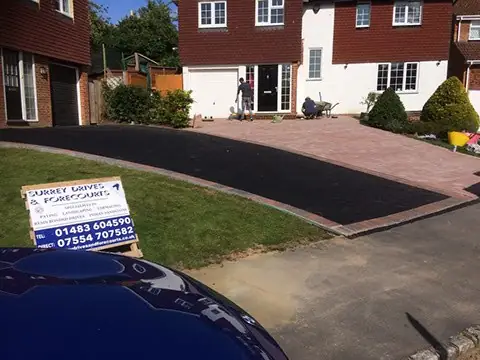 Tarmac driveway with red block edging and a lawn outside a detached house