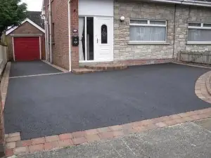 Tarmac driveway with a red block border outside a bungalow