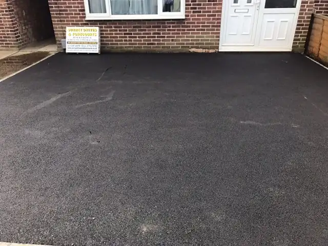 Close-up of a new tarmac driveway meeting its block paved edging